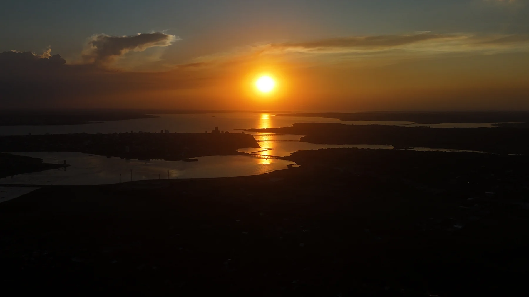 Fotografia aérea ao pôr do sol sobre o rio e a cidade